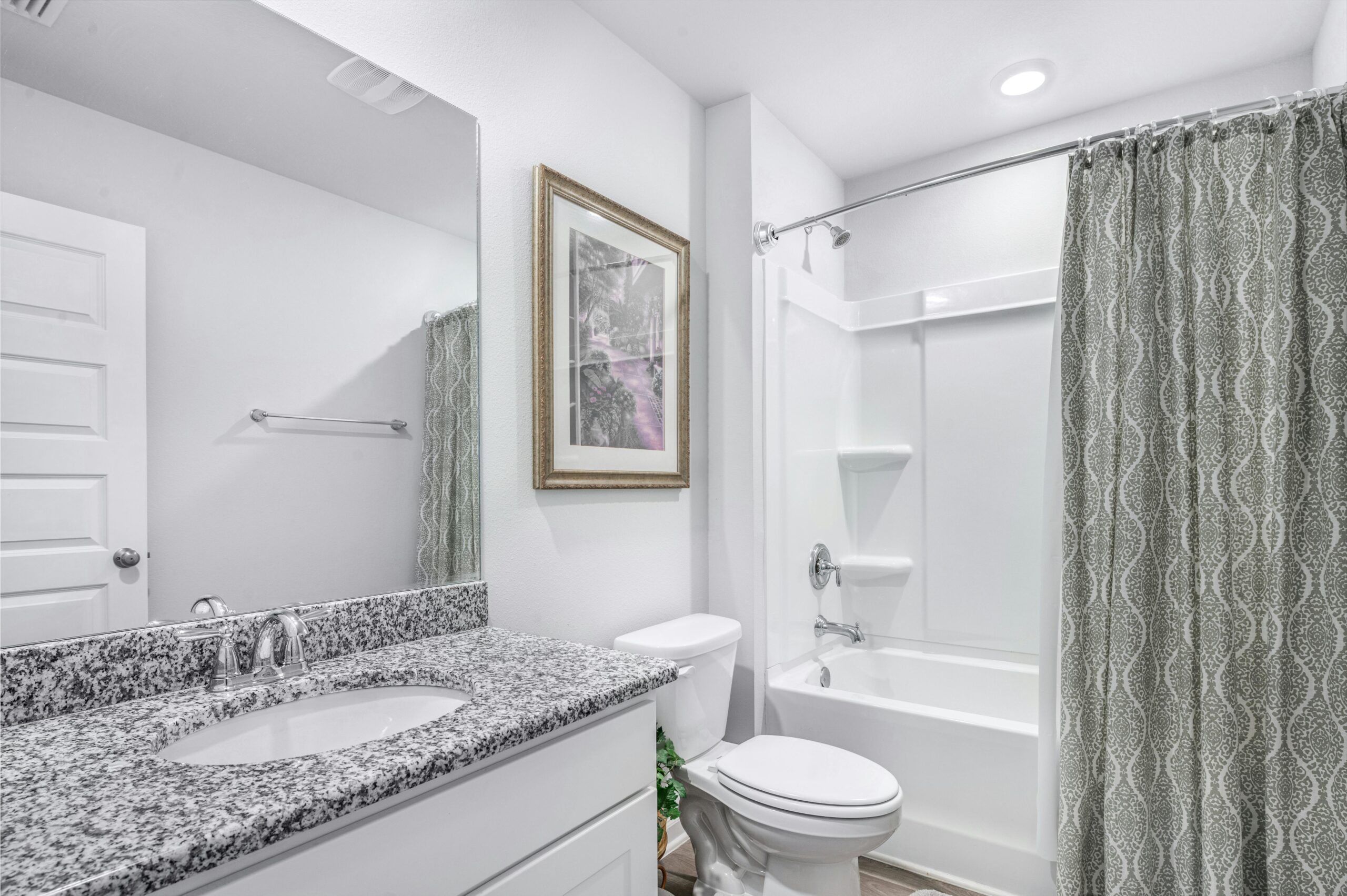 Maple Grove Bright and clean modern bathroom with granite countertop and elegant decor.