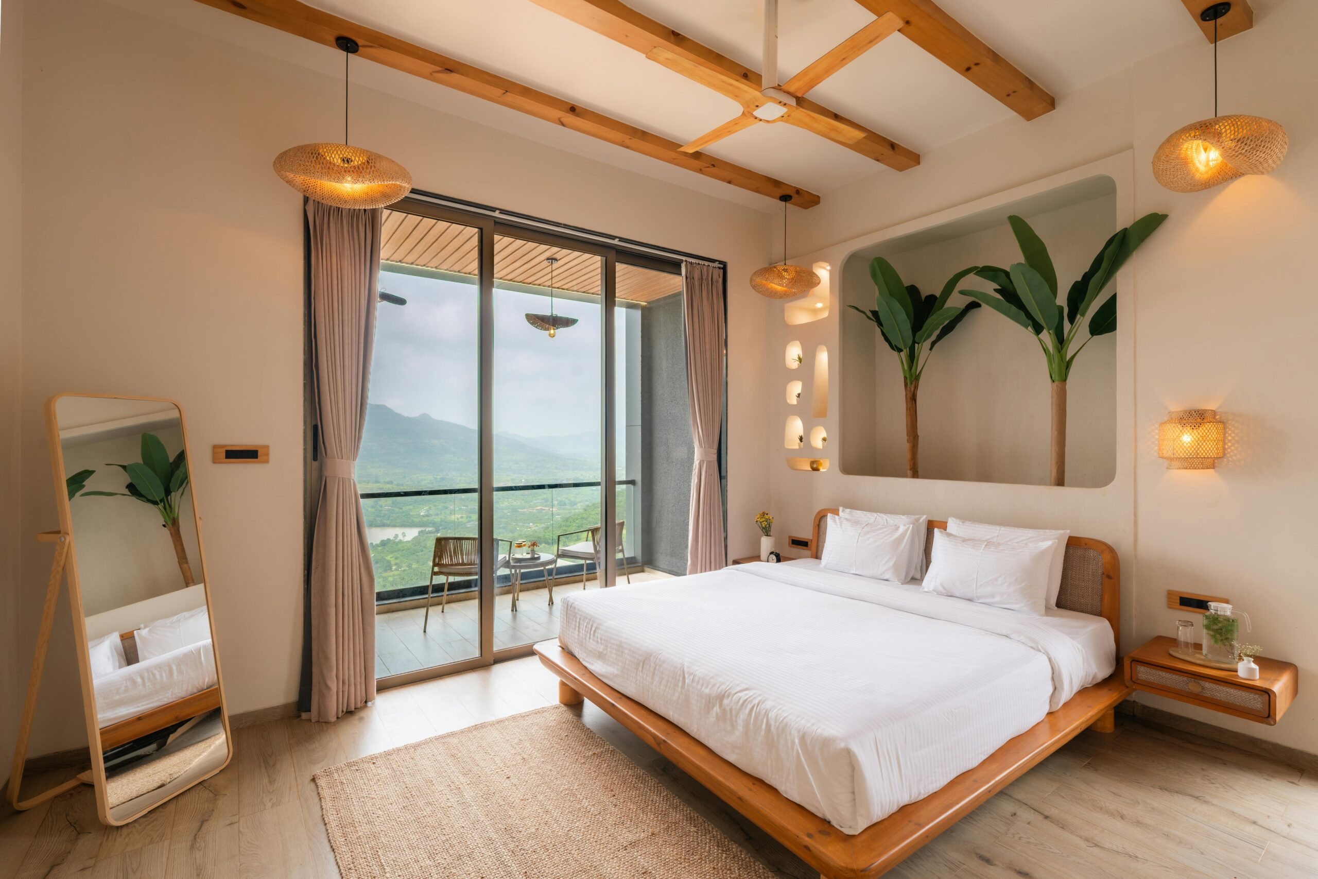 Sunset Haven Elegant bedroom with modern decor and a stunning mountain vista through large glass doors.
